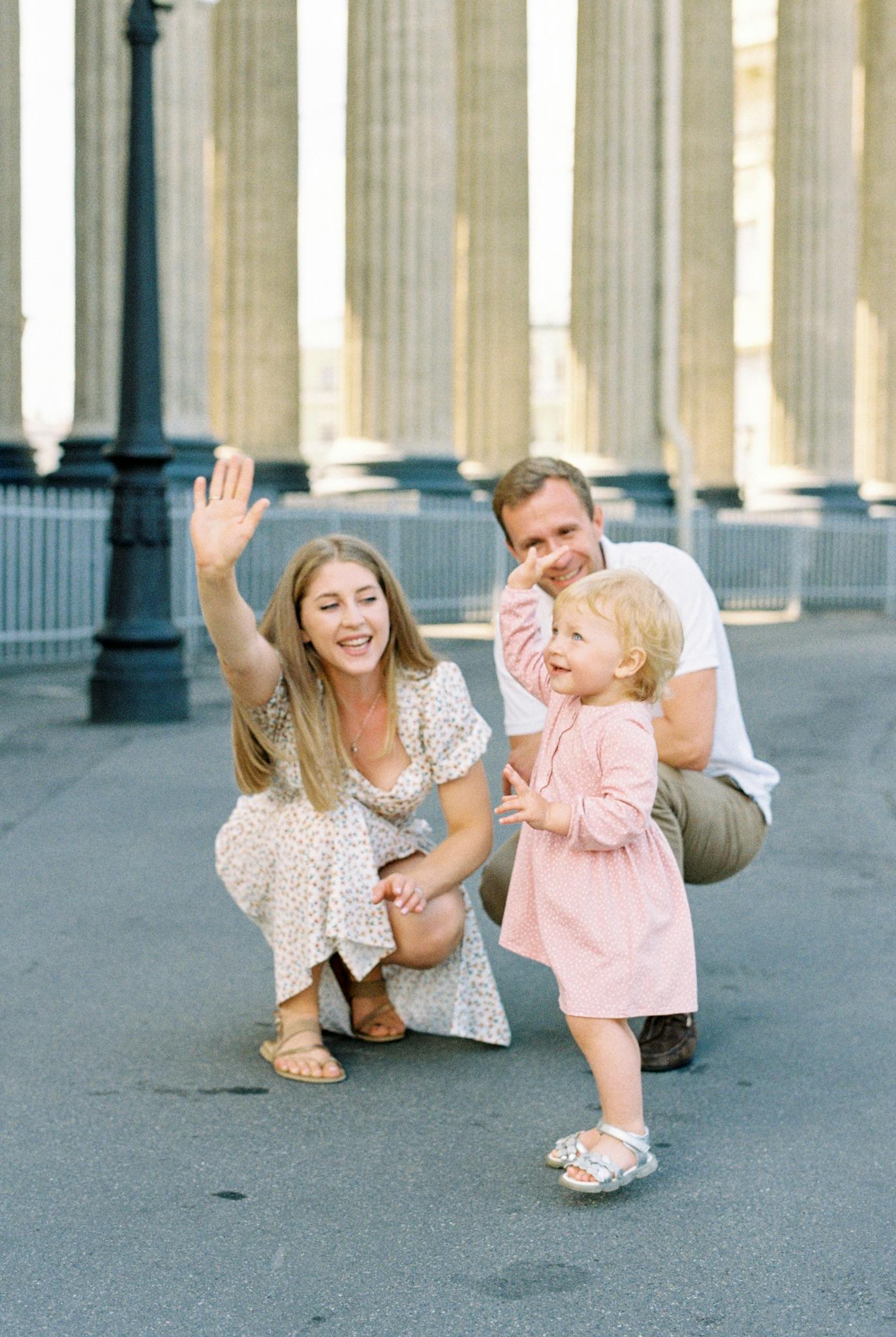 A happy family with a child playing outside Kazan Cathedral, St. Petersburg.